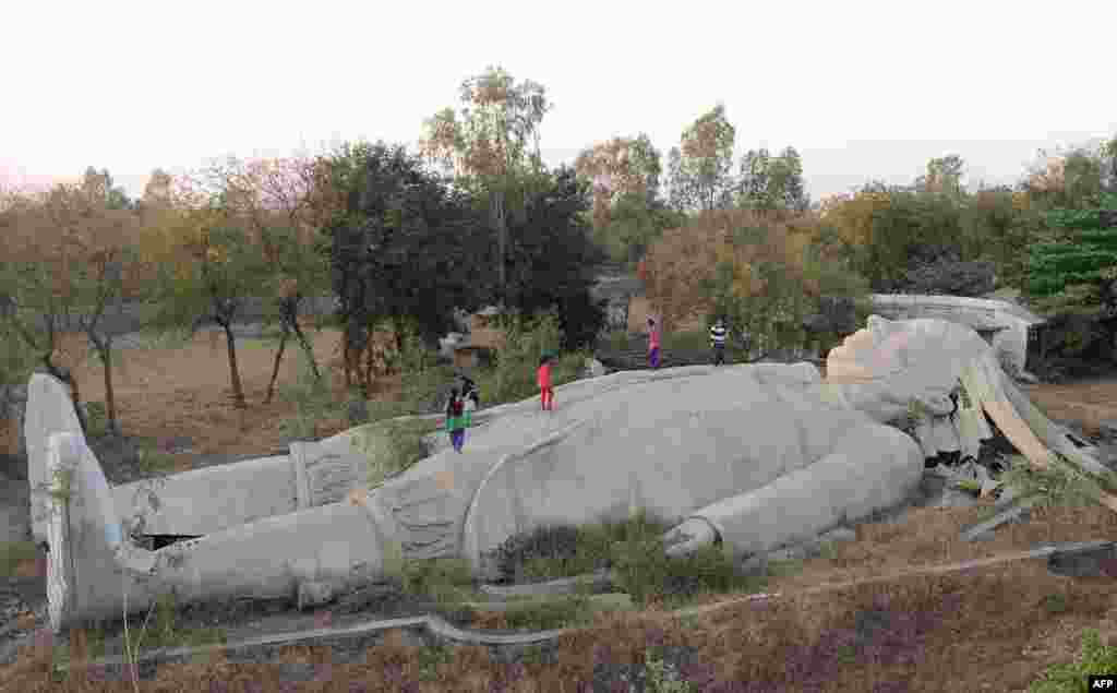 Indian children run over an incomplete model of a large male figure based on the character Lemuel Gulliver from the classic novel Gulliver's Travels, which was being used to teach youths about bodily functions, and had been receiving foreign funds for its completion, at the Navsarjan Trust's centre in Nani Devti village near Ahmedabad, Dec. 23, 2016.