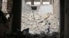 A child walks past damaged buildings after an airstrike in the rebel-held area of Aleppo's Baedeen district, Syria, May 3, 2016.