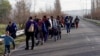 FILE - Migrants trudge toward a makeshift refugee camp in the northern Greek border station of Idomeni, where they hope to get permission to move onto other points in Europe, March 4, 2016. (J. Dettmer/VOA) 