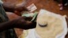 A Malawian trader counts money as he sells maize near the capital Lilongwe, Malawi, Feb. 1, 2016. 