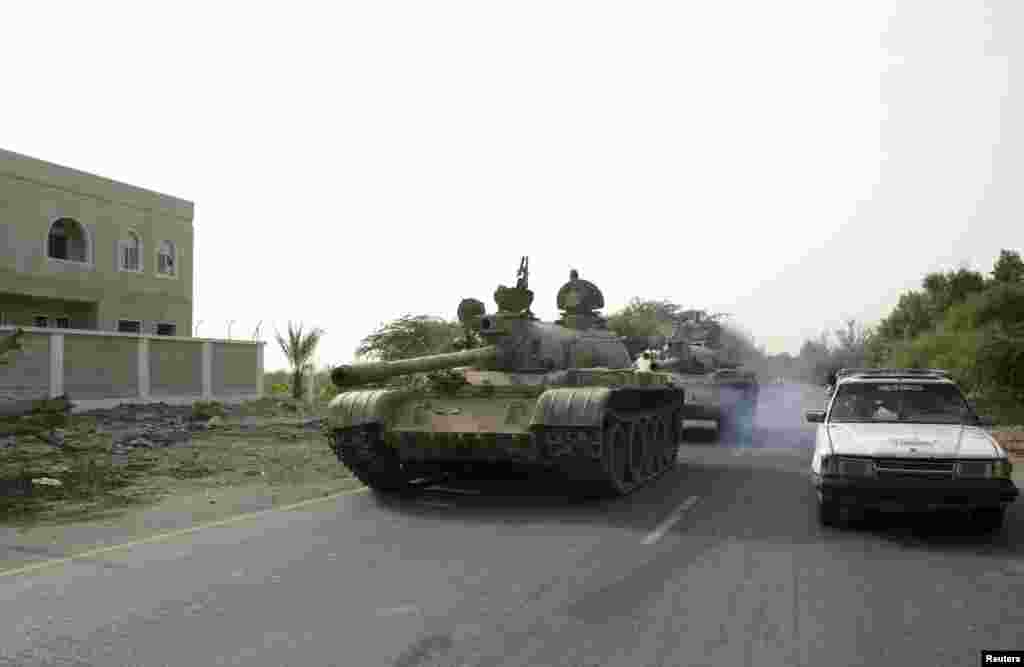 Army tanks drive on a street in the southern Yemeni city of Zinjibar, June 12, 2012.