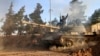 FILE - А volunteer fighter with Syrian government forces sits atop a tank in the province of Raqqa, Syria, Feb. 17, 2016. Backed by Russia and Iran, Syrian forces seen as much better positioned than the U.S.-led coalition and its regional allies to take 