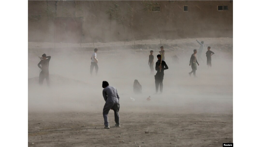 Ko'chada futbol o'ynayotgan afg'on yoshlar