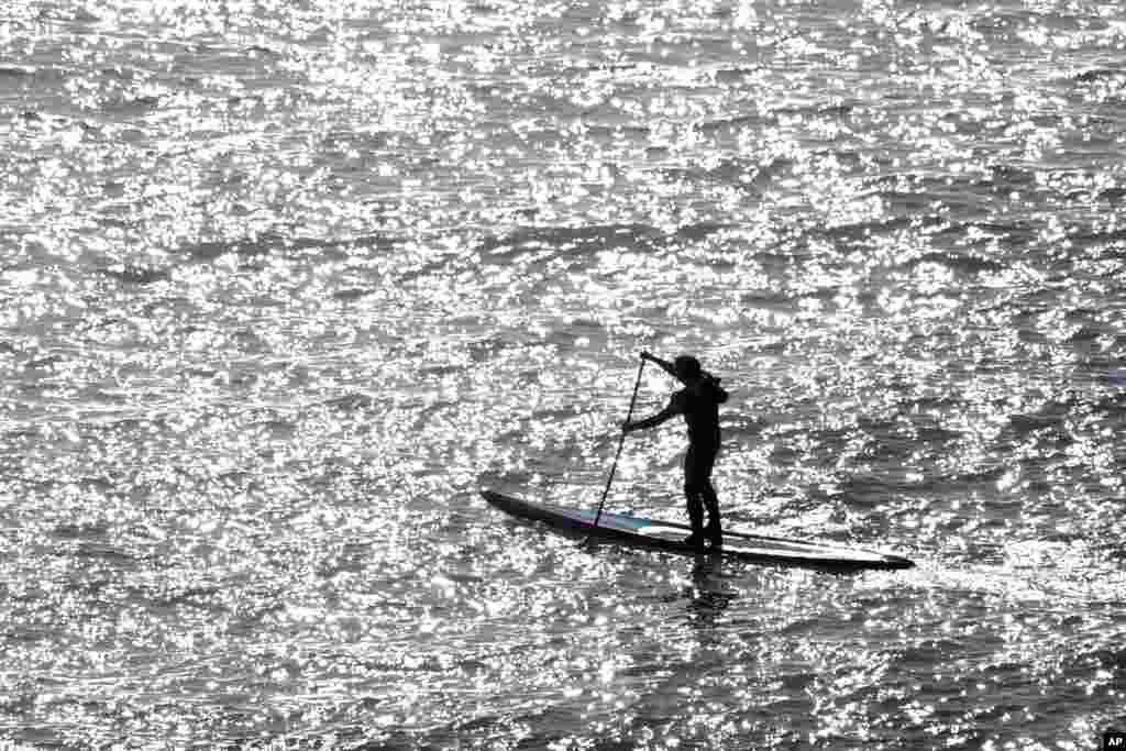 A surfers paddles near the Mavericks surf spot off Pillar Point Harbor, Dec. 21, 2016, in Half Moon Bay, California.