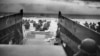FILE - Under withering Nazi fire from the shore, GIs who had just departed their Higgins Boat wade ashore at Normandy, France, June 6, 1944. (U.S. Coast Guard)