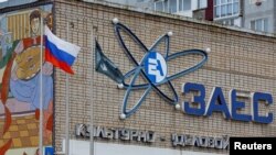Російський прапор вивішений біля культурно-ділового центру з логотипом Запорізької атомної електростанції в місті Енергодар Запорізької області, окупованому росіїйськими військами. Україна, 24 листопада, 2022 року. REUTERS/Олександр Єрмоченко