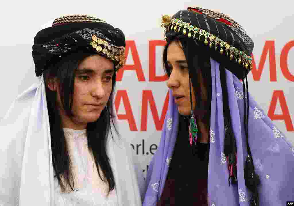 Nadia Murad (R) and Lamia Haji Bashar, public advocates for the Yazidi community in Iraq and survivors of sexual enslavement by the Islamic State jihadists react after being awarded laureates of the 2016 Sakharov human rights prize, at the European parliament in Strasbourg, France.