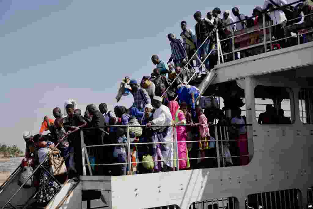 A ferry carrying people who fled Gambia arrives at the port in Banjul one day after defeated leader Yahya Jammeh left the country.&nbsp;Gambia&#39;s capital was awaiting the arrival of the country&#39;s new leader and an era of democracy, hours after the authoritarian ruler of 22 years flew into exile with an extraordinary set of assurances from the international community.&nbsp;