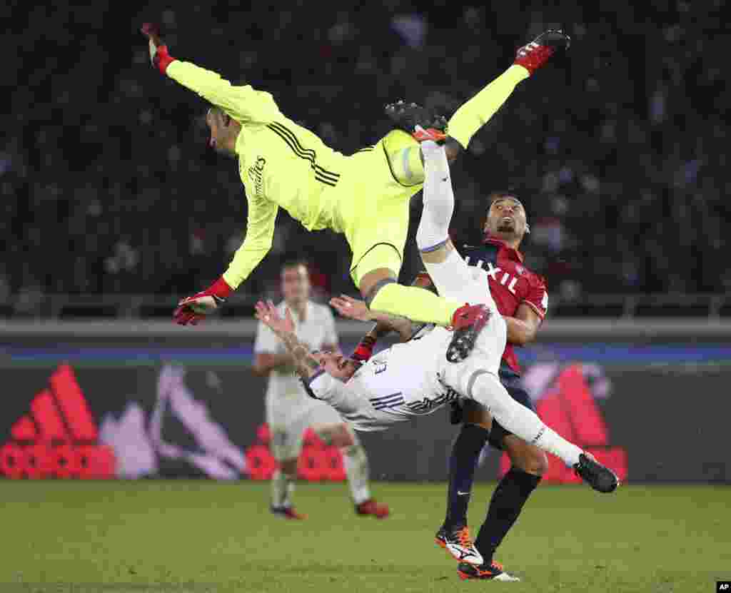 Kashima Antlers' Fabricio, right, collides with Real Madrid's Sergio Ramos, bottom, and goalkeeper Keylor Navas for a ball battle during their final match at the FIFA Club World Cup soccer tournament in Yokohama, near Tokyo, Japan.