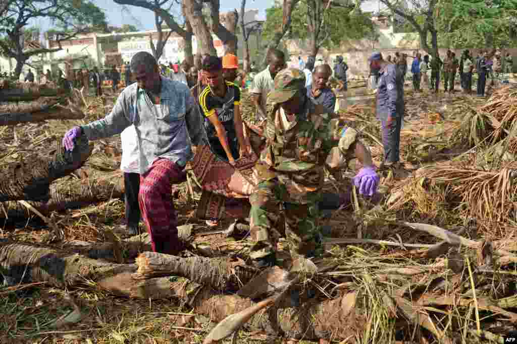 People carry the body of a victim at the scene of a car bomb attack near the port of the capital Mogadishu, Somalia.&nbsp;More than 20 people were killed in a suicide truck bombing in the capital , police said, in a fresh strike claimed by the Al-Qaeda-linked al-Shabab group.