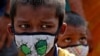 Children wearing protective masks wait to enter the Lokmanya Tilak Terminus railway station, amidst the spread of the COVID-19 in Mumbai, India, April 14, 2021. 