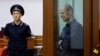 FILE - Wall Street Journal reporter Evan Gershkovich, who stands trial on espionage charges, reacts inside an enclosure for defendants before a court hearing in Yekaterinburg, Russia, June 26, 2024.