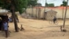 FILE - A man rides a bicyle in the town of Amchide, northern Cameroon, on the border with Nigeria, June 17, 2014. 