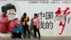 2014年3月2日昆明火车站外“中国梦”宣传海报下的乘客