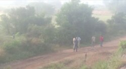 Still frame taken from Dec. 6, 2019, video shows policemen and officials standing at a spot where police shot to death four men suspected of raping a veterinary doctor, in Hyderabad, Telangana, India.