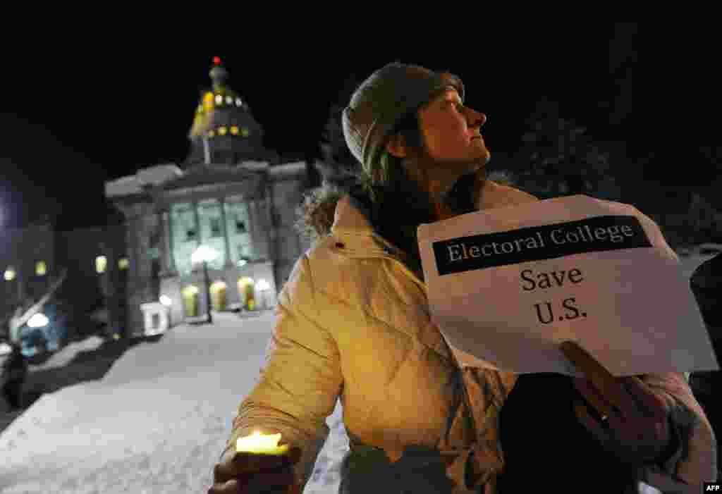 Ruth Fulton, 44, protests during a candlelight vigil against U.S. President-elect Donald Trump outside the Colorado Capitol building on the eve of the Electoral College vote, in Denver, Colorado, Dec. 18, 2016.