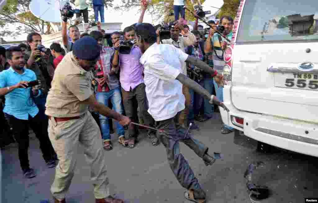 A policeman uses a baton to disperse the crowd as V. K. Sasikala (not pictured), general secretary of All India Anna Dravida Munnetra Kazhagam (AIADMK) and confidante of former Tamil Nadu Chief Minister Jayalalithaa Jayaram, arrives to surrender, outside the central jail in Bengaluru, India.