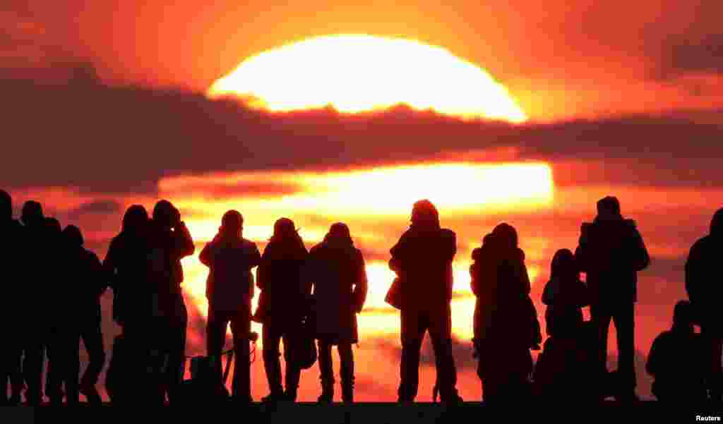 People watch the first sunrise on New Year's Day at Yuriage district in Natori, Miyagi prefecture, Japan, in this photo taken by Kyodo.