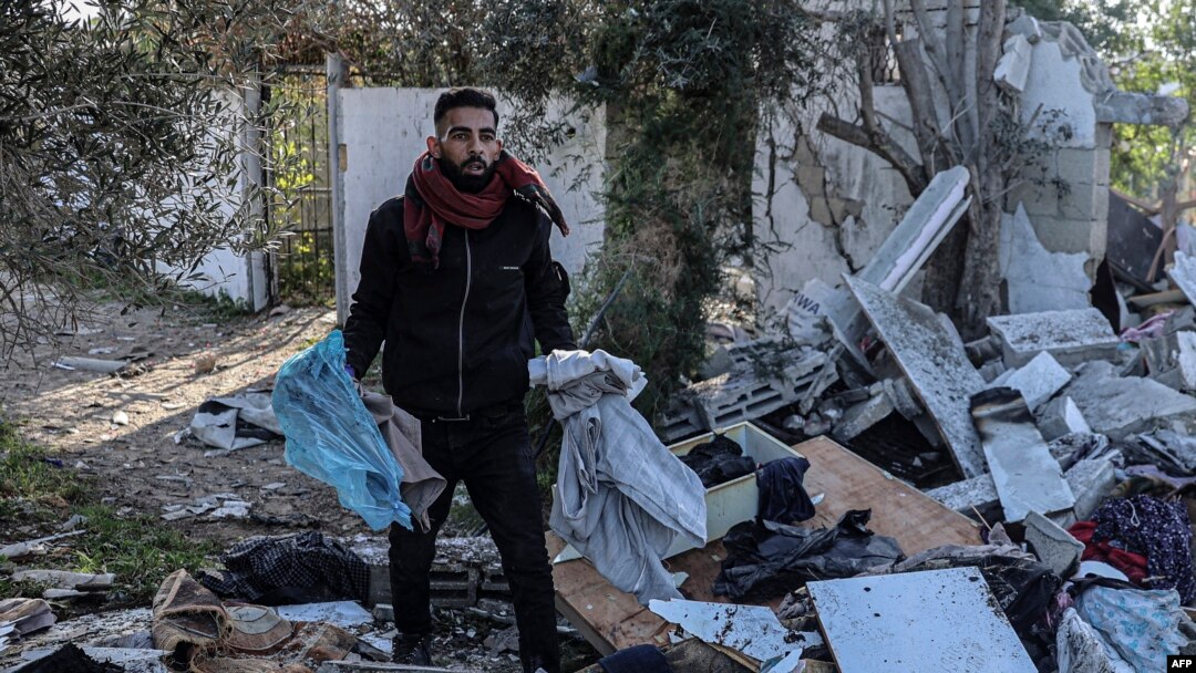 Vayronaga aylangan uyidan omon qolgan narsalarni izlayotgan falastinlik, Rafah shahri, G'azo sektori, 11-mart, 2024. 