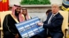 President Donald Trump shows a chart highlighting arms sales to Saudi Arabia during a meeting with Saudi Crown Prince Mohammed bin Salman in the Oval Office of the White House, Tuesday, March 20, 2018, in Washington.