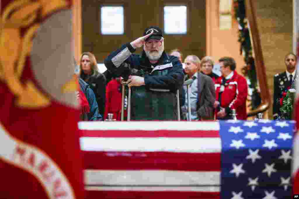 A mourner salutes the casket of John Glenn as he lies in honor in Columbus, Ohio.