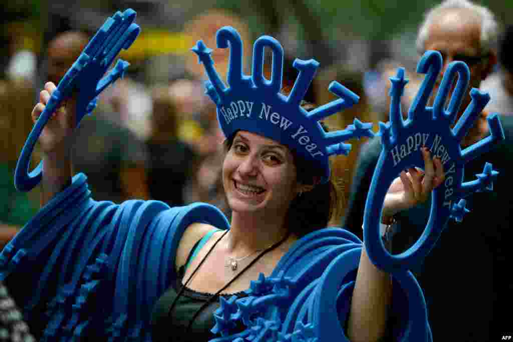 A woman sells "Happy New Year 2017" headwear on a shopping street in Sydney, Australia.