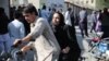 A woman arrives on a motorbike to search for a relative at a hospital in Kabul on Sept. 30, 2022, after a blast in a learning center in the Dasht-e-Barchi area of Afghanistan's capital.