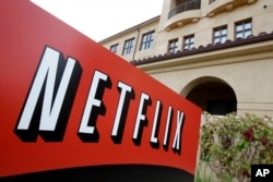 FILE - A sign points to Netflix headquarters in Los Gatos, Calif.