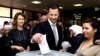 Syrian President Bashar al-Assad casts his ballot in parliamentary elections as wife Alma, left, observes, in Damascus, April 13, 2016. The photo was posted on the official Facebook page of the Syrian Presidency. 
