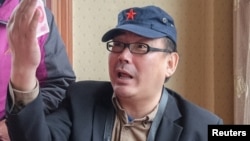 Yang Hengjun, author and former Chinese diplomat, who is now an Australian citizen, gestures in an unspecified location in Tibet, China, in mid-July 2014, in this social media image.