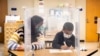 FILE - Pre-kindergarten teacher Sarah McCarthy works with a student at Dawes Elementary in Chicago, Jan. 11, 2021. 
