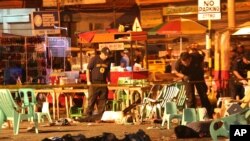Philippine police officers look at dead victims after an explosion at a night market that has left about 10 people dead and wounded several others in southern Davao city, Philippines late Friday Sept. 2, 2016. 