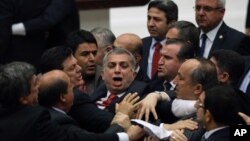 FILE - Ruling Justice and Development Party lawmakers and members of the Republican People's Party skirmish during debate on corruption charges against ministers in the cabinet of then-Prime Minister Recep Tayyip Erdogan in Ankara, Turkey, May 5, 2014.