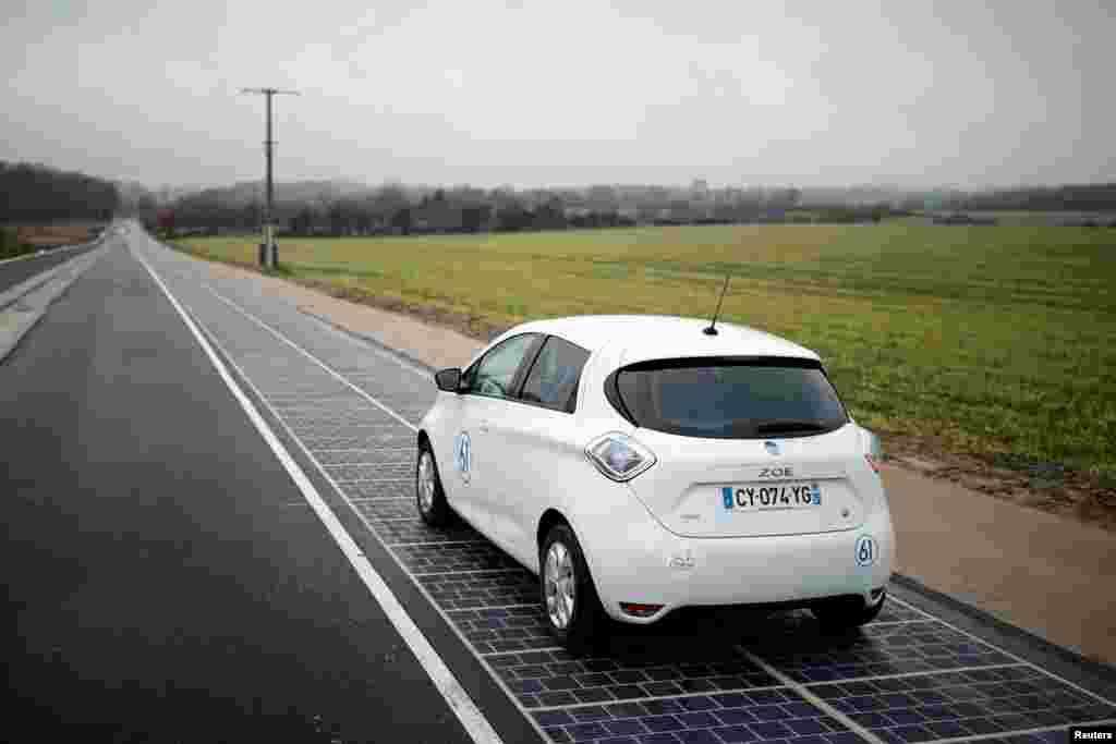 An automobile drives on a solar panel road during its inauguration in Tourouvre, Normandy, northwestern France.