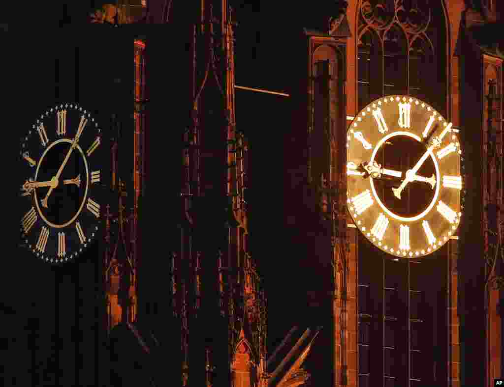 Sun light shines on one of the clocks on the cathedral in Frankfurt, Germany, on a cold and sunny day.