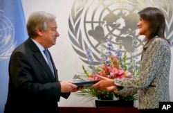 Former South Carolina Governor Nikki Haley, right, presents her credentials to United Nations Secretary General Antonio Guterres, left, as the new U.S. Ambassador to the United Nations at U.N. headquarters, Jan. 27, 2017.