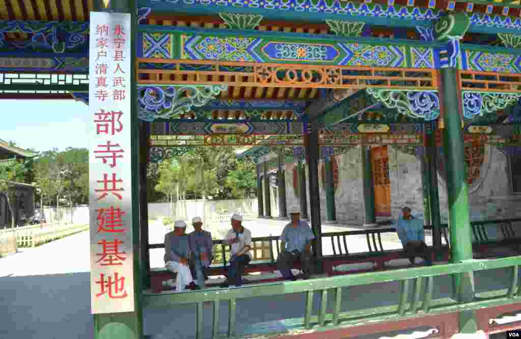 参加祈祷的回族老人与邻居聊天，他们是纳家户寺庭院的常客。