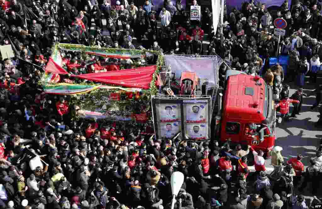 Iranians firefighters and mourners gather around a fire truck carrying the coffins of firemen killed when the city's oldest high-rise collapsed after a blaze, during the funeral ceremony in the capital Tehran.