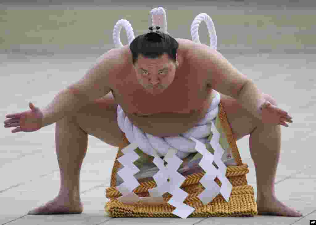 Sumo grand champion Hakuho of Mongolia performs his ring entry forms at the Meiji Shrine in Tokyo, Japan. The Shinto ritual is part of the annual New Year's celebrations at the shrine.