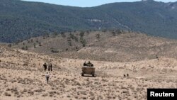 FILE - Tunisian soldiers patrol near the border with Algeria as seen from the area of Mount Chambi.