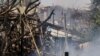 A firefighter extinguishes a blaze at the scene where a rocket launched from the Gaza Strip landed, causing fatalities, on a farm just over the Gaza border, in Moshav Ohad, southern Israel, May 18, 2021.