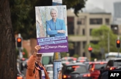 A supporter of high-profile independent candidate for Sydney's Wentworth electoral district Kerryn Phelps holds up a placard of her, outside a polling station during the Wentworth by-election in Sydney, Australia, Oct. 20, 2018.