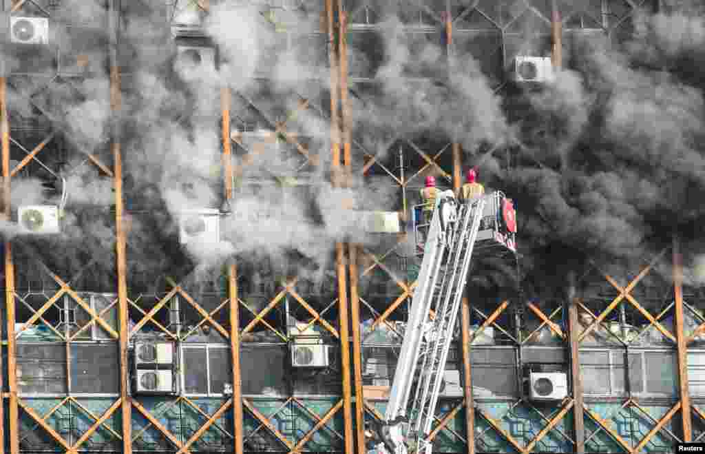Firefighters try to put out fire in a blazing high-rise building in Tehran, Iran.