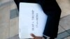 Omar Jadwat, director of the ACLU's Immigrants' Rights Project, carries court documents after a news conference outside a federal courthouse in Greenbelt, Md., Oct. 16, 2017.