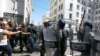 FILE - Demonstrators face police officers in Algiers, May 7, 2021, as a crowd of protesters marched in the streets of Algeria's capital in support for the Hirak pro-democracy movement.