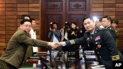 지난달 14일 한국 경기도 파주 판문점 북측 통일각에서 열린 장성급 군사회담에서 김도균 남측 수석대표(오른쪽)와 안익산 북측 수석대표가 악수를 하고 있다. 앞서 지난 17일 남북한 군 당국이 서해지구 군 통신선을 29개월 만에 완전히 복구해 정상화한 가운데 동해지구 군 통신선의 완전 복구도 진행 중에 있다. 