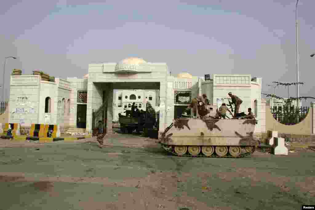Army soldiers guard the gate of the local authority's compound in the southern Yemeni city of Zinjibar after the army retook the city from al-Qaida-linked militants, June 12, 2012.