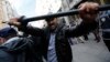 FILE - A plainclothes police officer reacts against journalists during a protest by anti-government demonstrators in central Istanbul, May 2014.