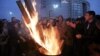Cheering fans of the Besiktas soccer team gather around a fire outside a courthouse as a trial of dozens of football fans proceeds inside in Istanbul, Dec. 16, 2014.