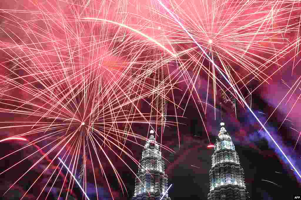 Fireworks illuminate the sky near Malaysia's Petronas Twin Towers during New Year celebrations in Kuala Lumpur.